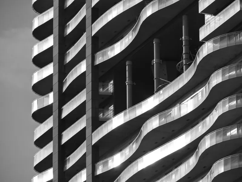 Curving balconies of an apartment block in black and white